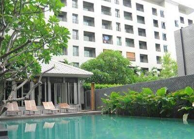 Condominium pool area with lounges and greenery