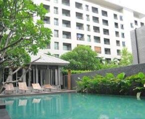 Condominium pool area with lounges and greenery