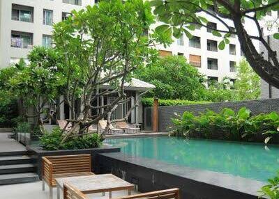 Outdoor pool area with greenery and nearby seating