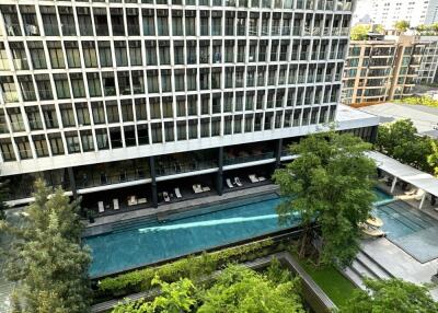 Exterior view of a modern condo building with a swimming pool