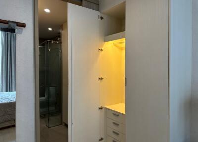 Interior view of a bedroom closet with open doors showing shelves, hangers and drawers