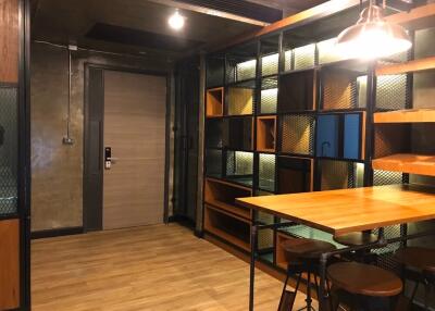 Modern industrial style living space with built-in shelves and a high table