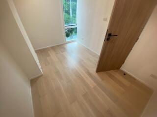 Bedroom with wooden flooring and a window