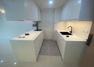 Modern white kitchen with cabinets, sink, and lighting