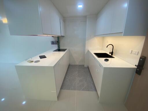 Modern white kitchen with cabinets, sink, and lighting