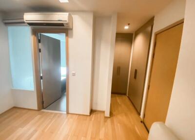 A view of the bedroom featuring wooden floors, an AC unit, and closet space.