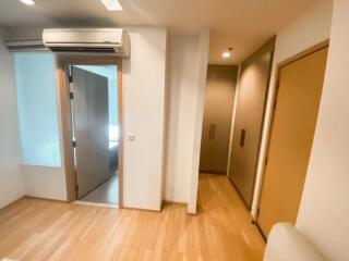 A view of the bedroom featuring wooden floors, an AC unit, and closet space.