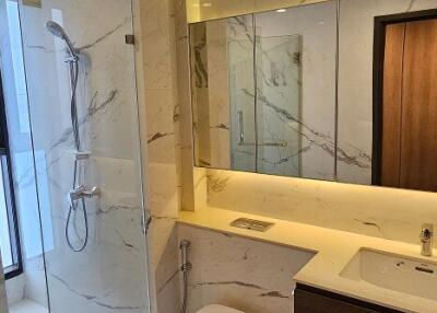 Modern bathroom with glass shower enclosure and marble finishes