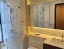 Modern bathroom with glass shower enclosure and marble finishes