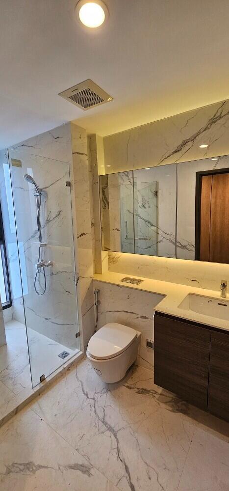 Modern bathroom with glass shower enclosure and marble finishes