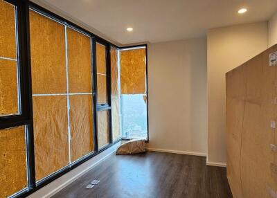 Partially furnished bedroom with large windows