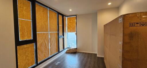 Partially furnished bedroom with large windows