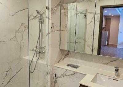 Modern bathroom with glass-enclosed shower and marble tiles