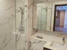 Modern bathroom with glass-enclosed shower and marble tiles