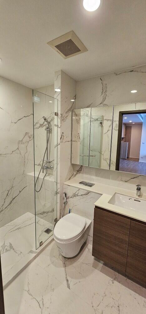 Modern bathroom with glass-enclosed shower and marble tiles