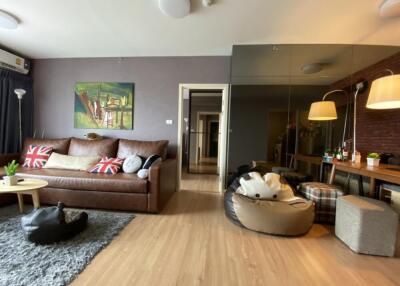 Modern living room with a leather sofa, beanbags, and a dining area