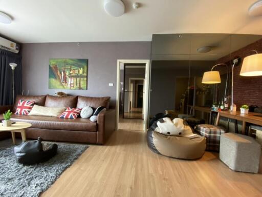 Modern living room with a leather sofa, beanbags, and a dining area