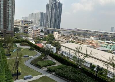 View from the building showcasing landscaped gardens, nearby structures, and transport links