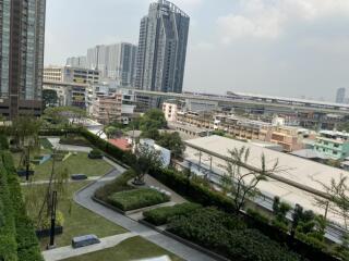 View from the building showcasing landscaped gardens, nearby structures, and transport links