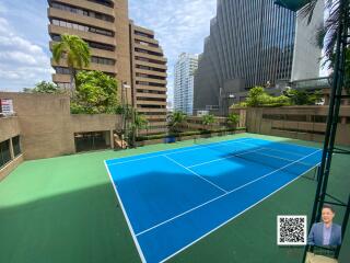 Apartment complex with tennis court and surrounding buildings