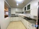 Modern kitchen with white cabinetry and tile flooring