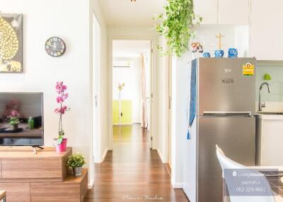 Bright living area with open kitchen, hallway, and decor