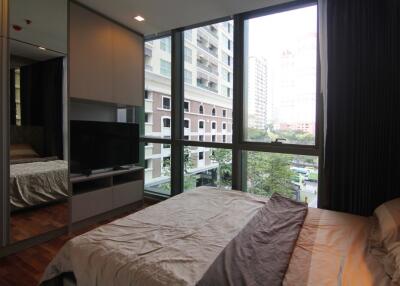 Bedroom with large windows and city view