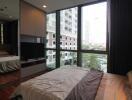 Bedroom with large windows and city view