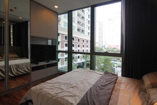 Bedroom with large windows and city view