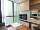 Modern living room with large windows, a flat-screen TV, and built-in shelves and drawers