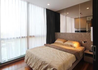 Modern bedroom with large windows and wooden flooring