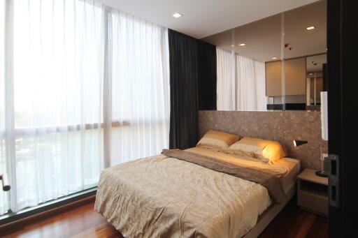 Modern bedroom with large windows and wooden flooring