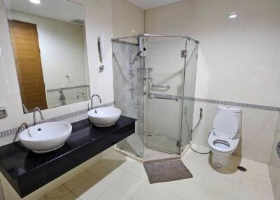 Modern bathroom with dual sinks and glass shower enclosure