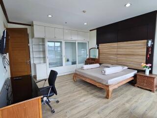 Spacious and well-lit bedroom with wooden flooring