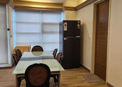 Modern dining area with chandelier and refrigerator