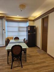 Modern dining area with chandelier and refrigerator