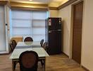 Modern dining area with chandelier and refrigerator