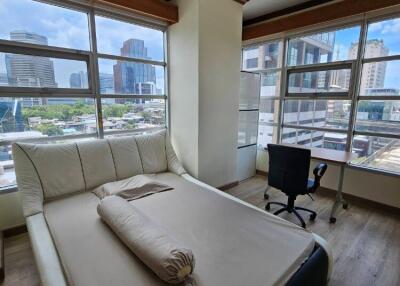 Bedroom with large windows and city view