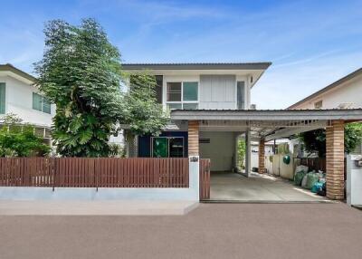 Two-story house with a front yard and carport