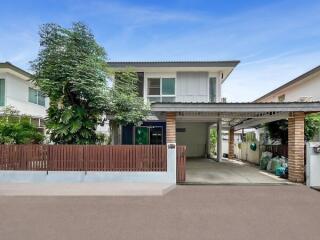 Two-story house with a front yard and carport