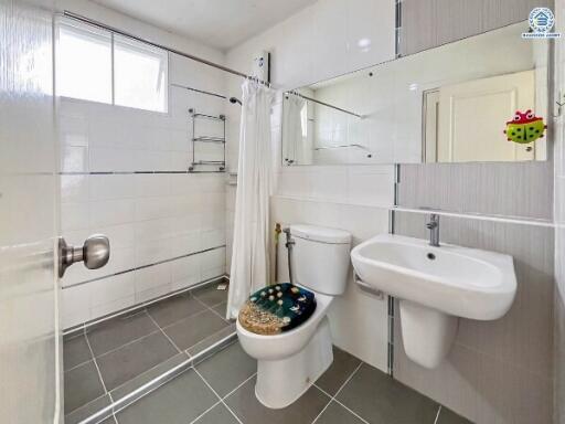 Modern bathroom with walk-in shower, sink, and toilet