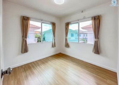 bright empty bedroom with large windows and wooden flooring