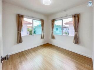 bright empty bedroom with large windows and wooden flooring