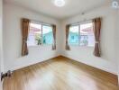 bright empty bedroom with large windows and wooden flooring