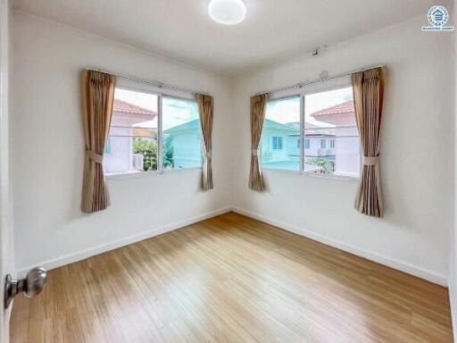 bright empty bedroom with large windows and wooden flooring