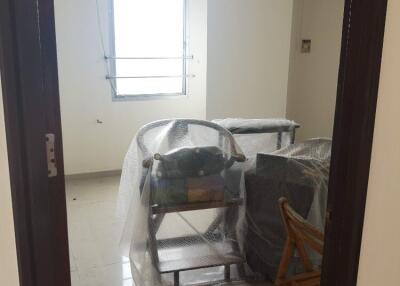 Small room with window and furniture covered in plastic