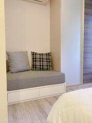 Cozy bedroom corner with a sitting area and pillows