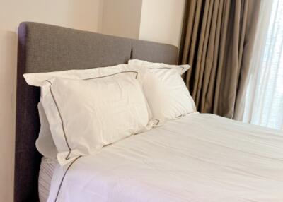 Modern bedroom with neatly made bed and natural light