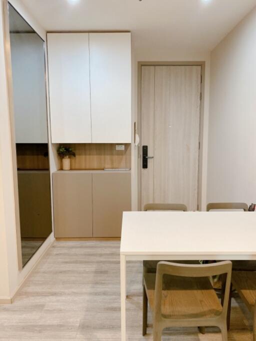 Small dining area with a table and four chairs, cabinet, and a door