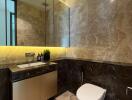 Modern bathroom with marble walls, illuminated mirror, and white toilet